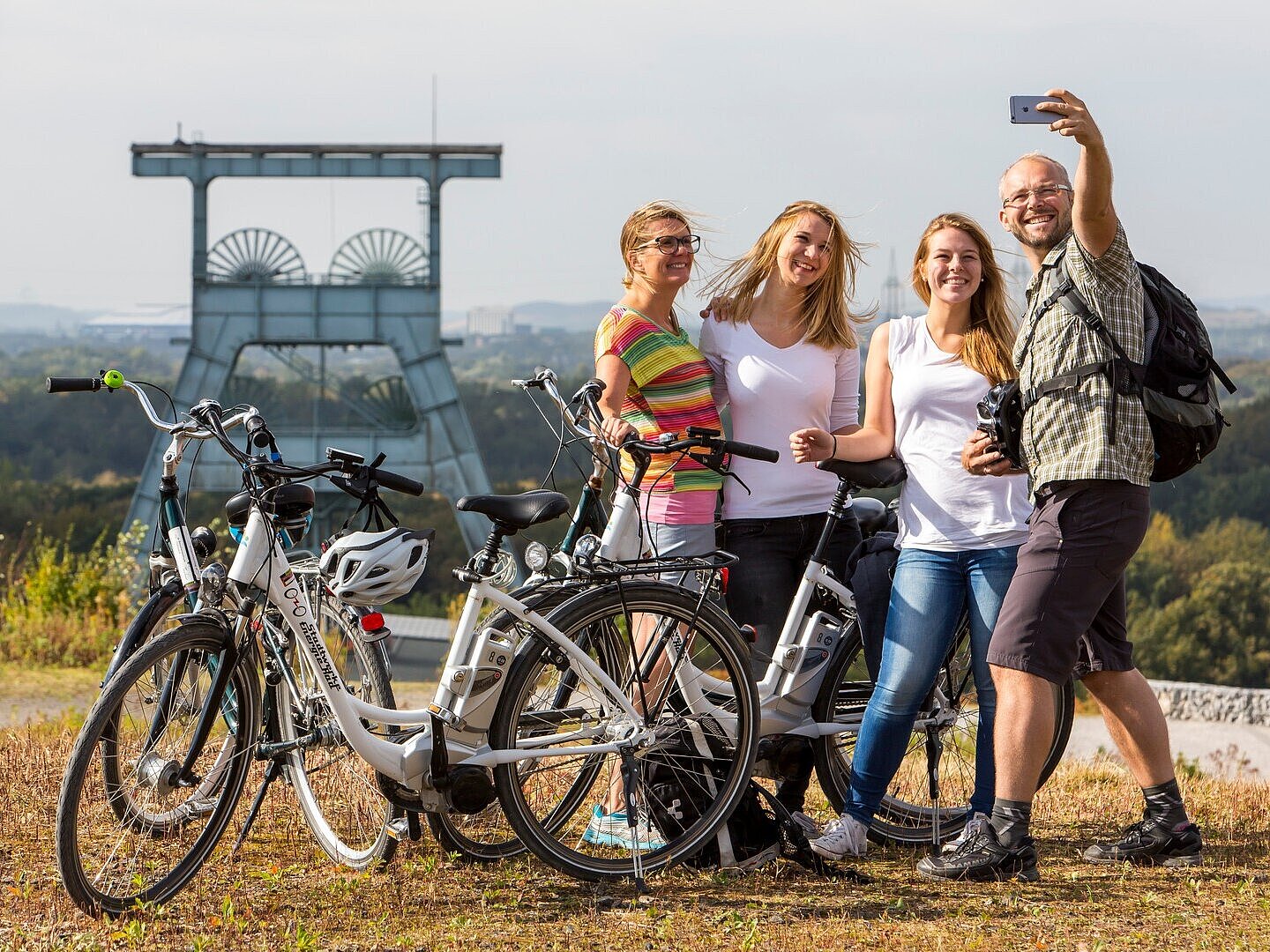Auf der Radtour wird ein Gipfelfoto mit Förderturm im Hintergrund gemacht.