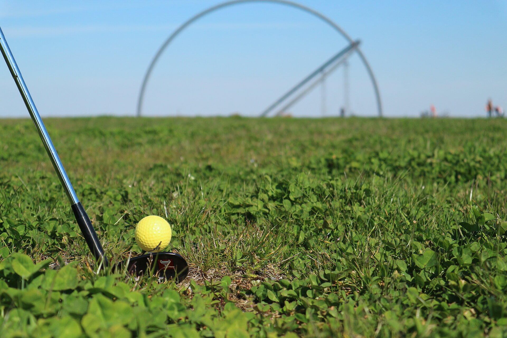 Nahaufnahme eines Golfschlägers mit Golfball vor dem Horizontobservatorium  
