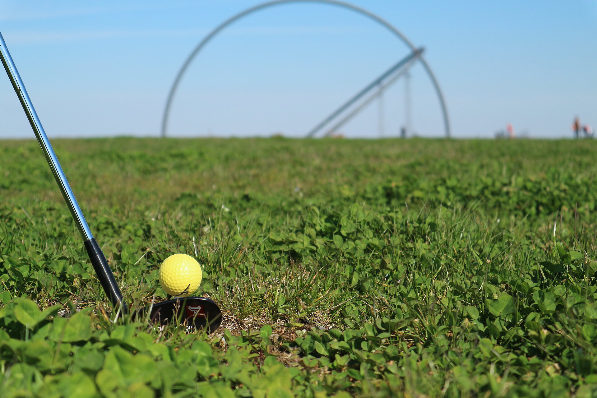 Nahaufnahme eines Golfschlägers mit Golfball vor dem Horizontobservatorium  
