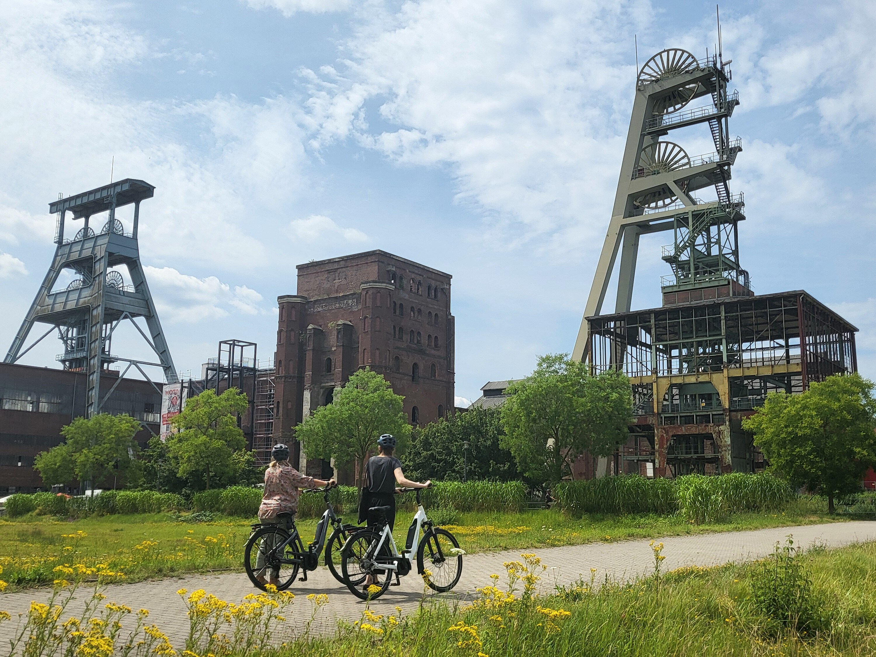 Zwei Personen fahren mit dem Fahrrad über das Gelände der ehemaligen Zeche Ewald.