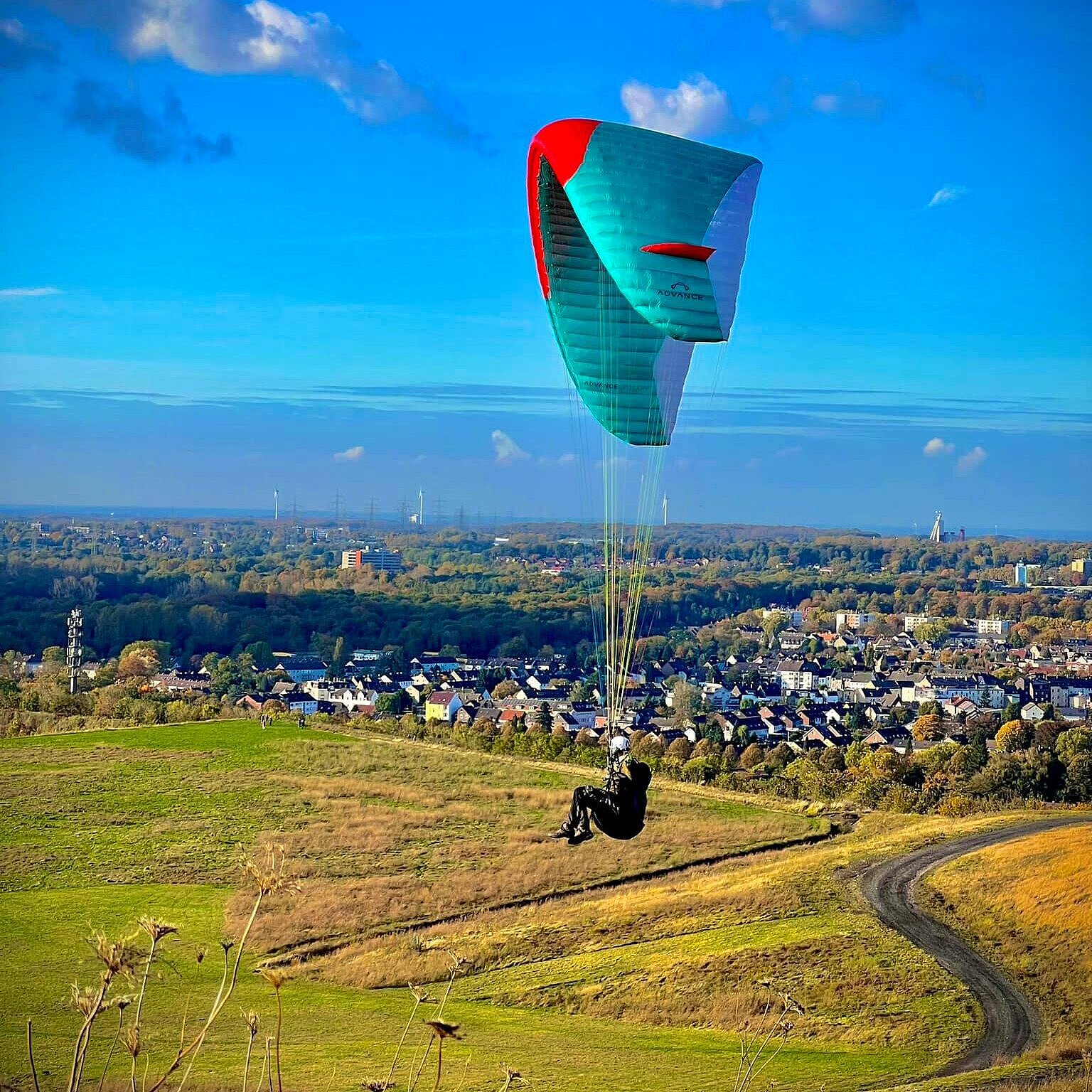 Paraglider gleitet mit Schirm von Westspitze Hoheward