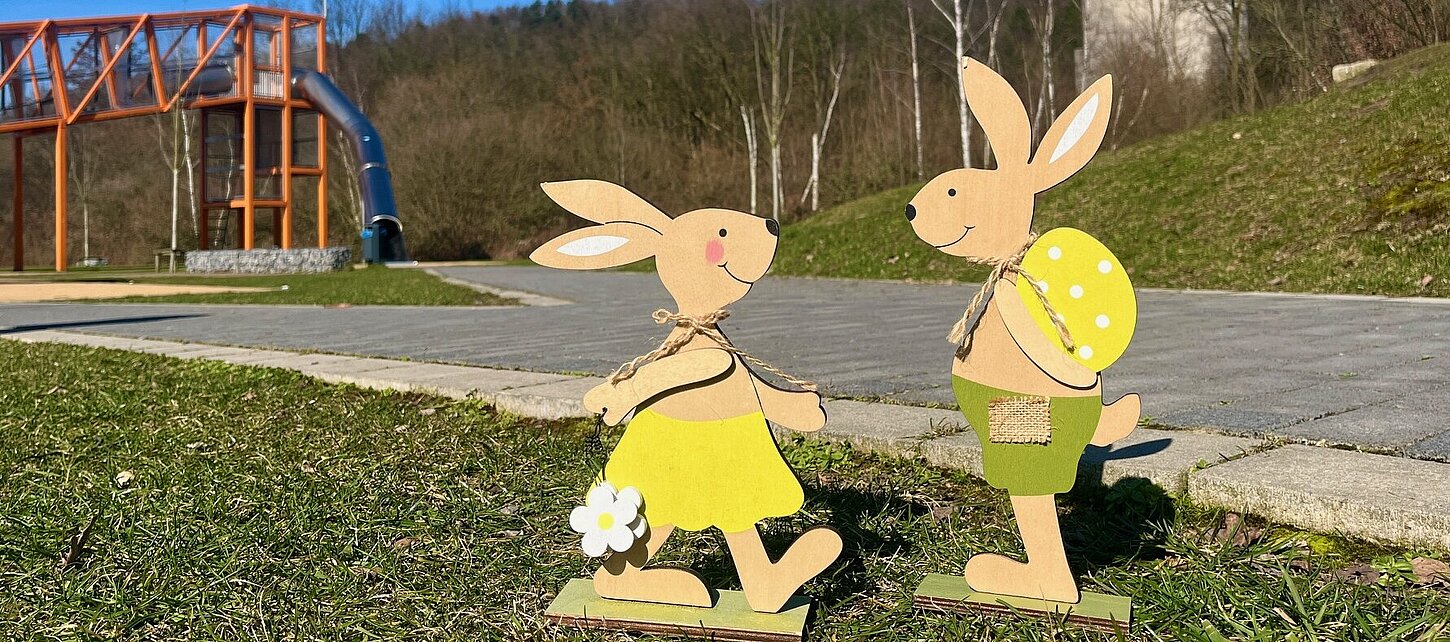 Zwei Osterhasen aus Holz auf einer Wiese im AktivLinearPark