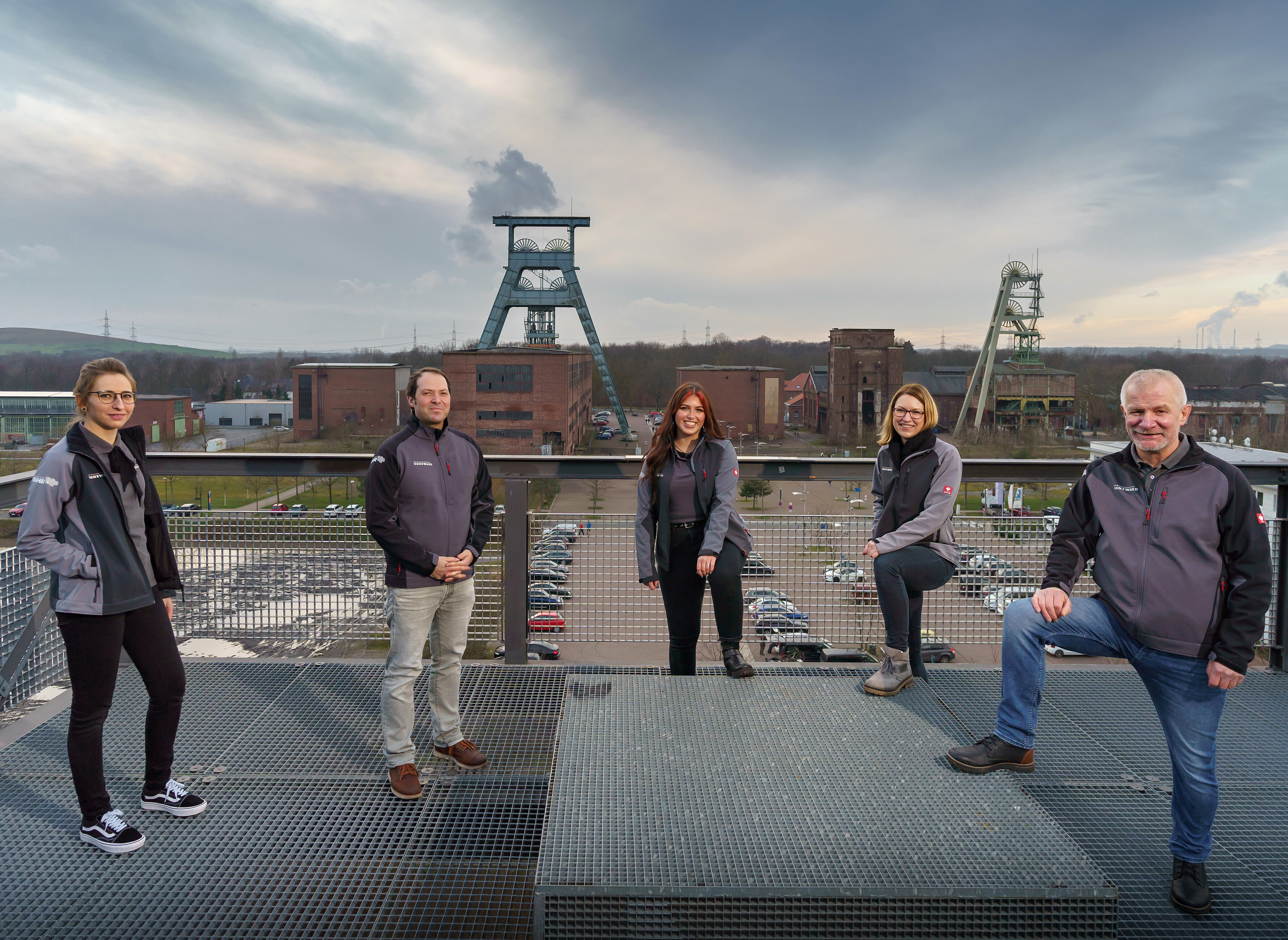 Die Mitarbeiter des Besucherzentrums auf einem Gruppenfoto auf der Halde, im Hintergrund die Zeche Ewald