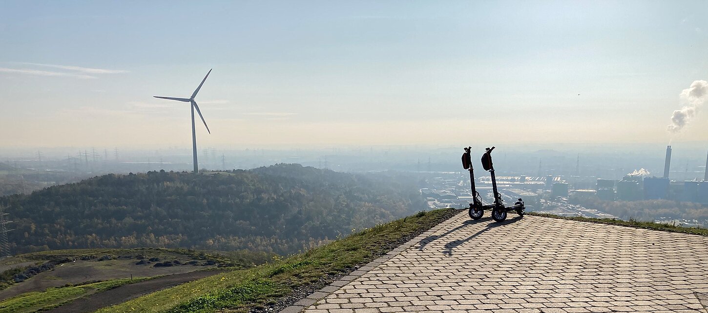 E-Scooter mit dem Windrad der Halde Hoppenbruch