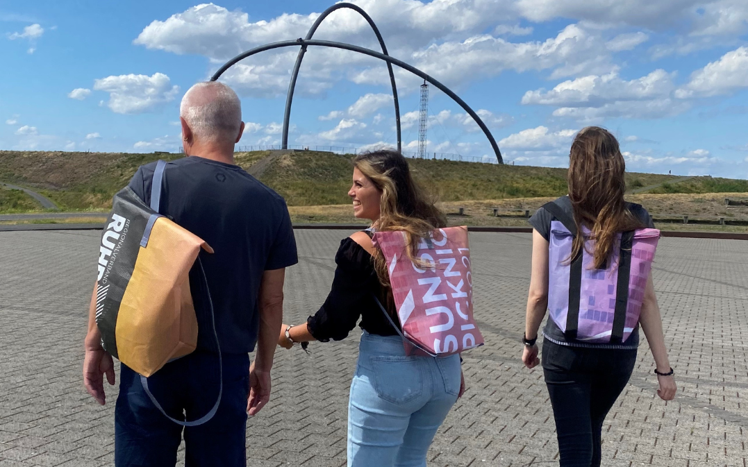 Gruppe aus Personen mit drei SunsetPicknick-Rucksäcken