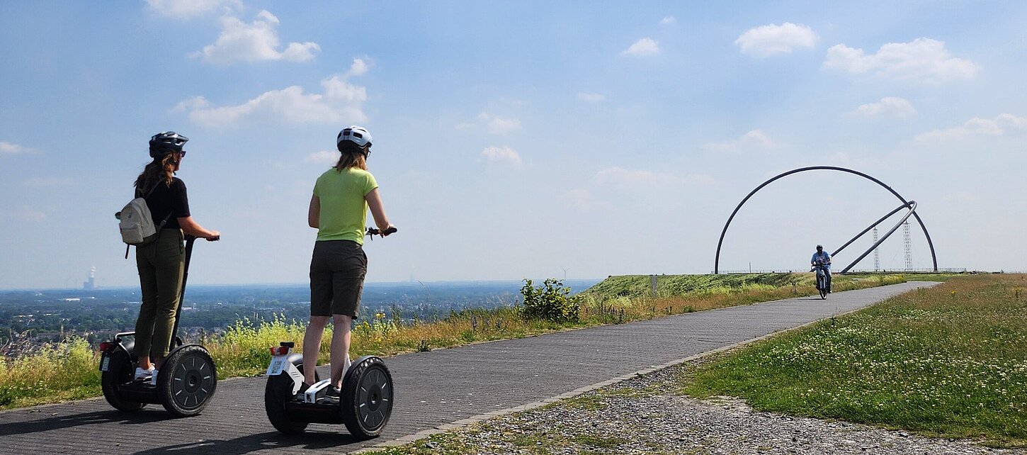 Zwei Segwayfahrer fahren in Richtung des Horizontobservatoriums auf der Halde Hoheward.