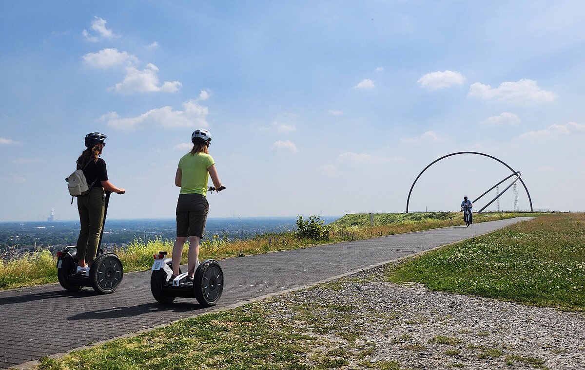 Zwei Segwayfahrer fahren in Richtung des Horizontobservatoriums auf der Halde Hoheward.