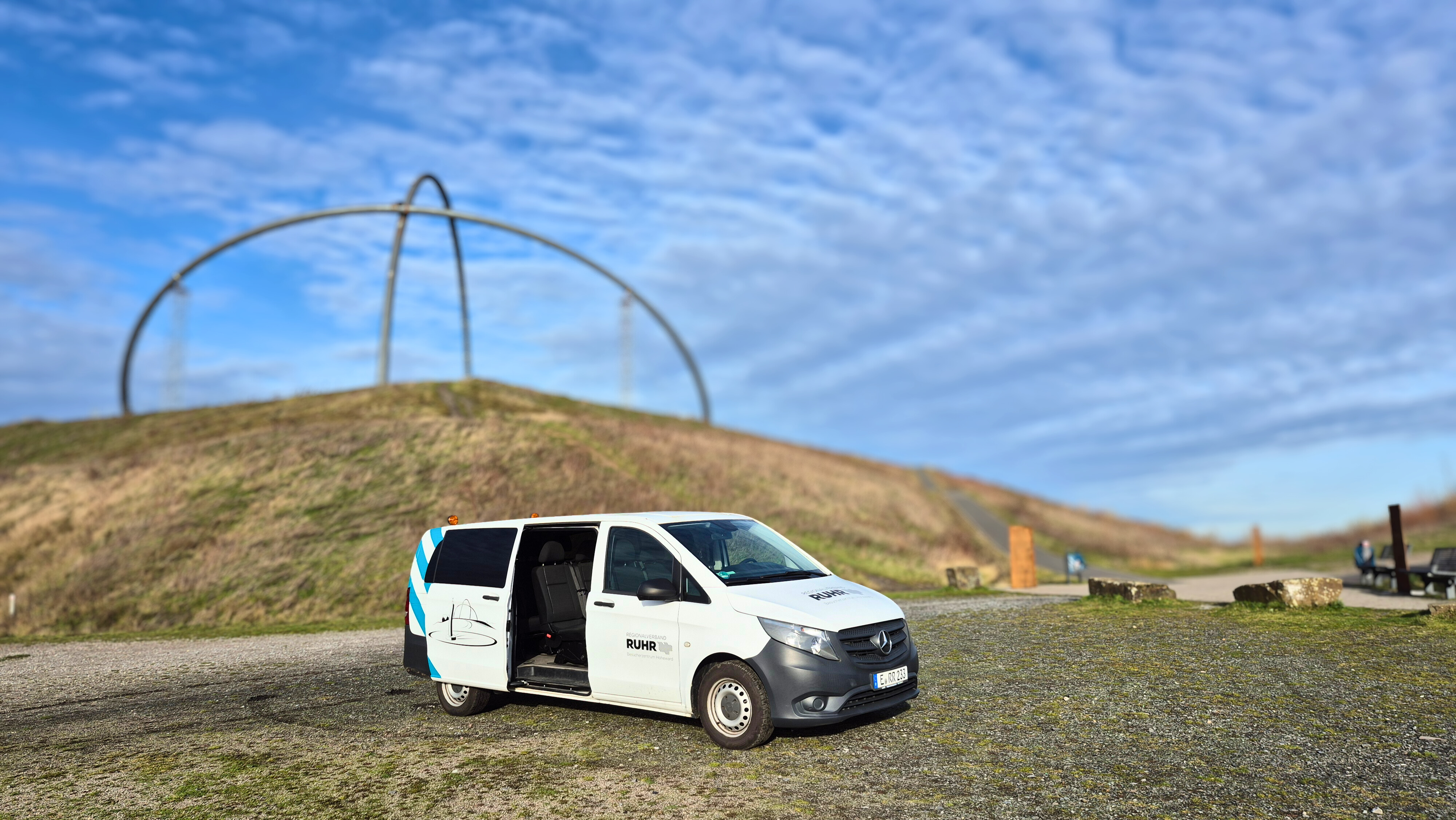 Kleinbusführung auf der Halde Hoheward Ein großes Auto mit offener Tür steht auf einer Ebene der Halde Hoheward. Im Hintergrund ist das Horizontobservatorium zu sehen.