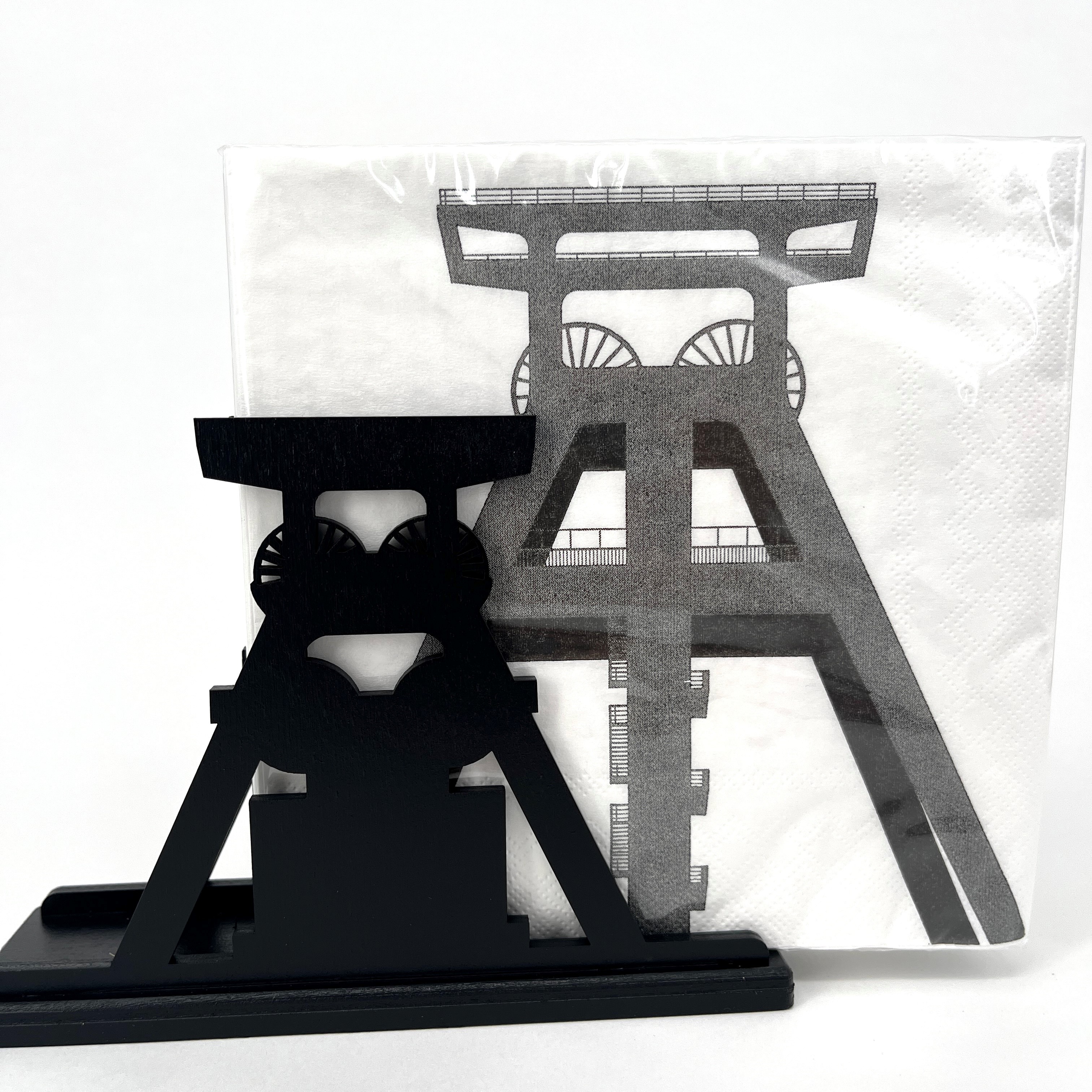 Serviettenhalter aus geschwärztem Holz in Form einer Fördergerüst-Silhouette mit dazu passenden Servietten mit Förderturm-Motiv